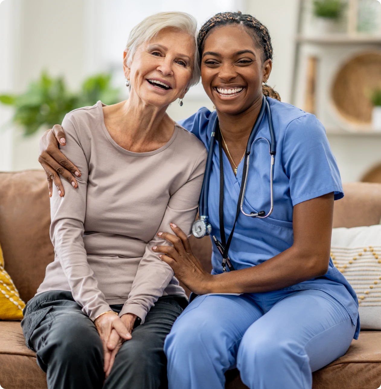 Nurse comforting elderly woman on couch