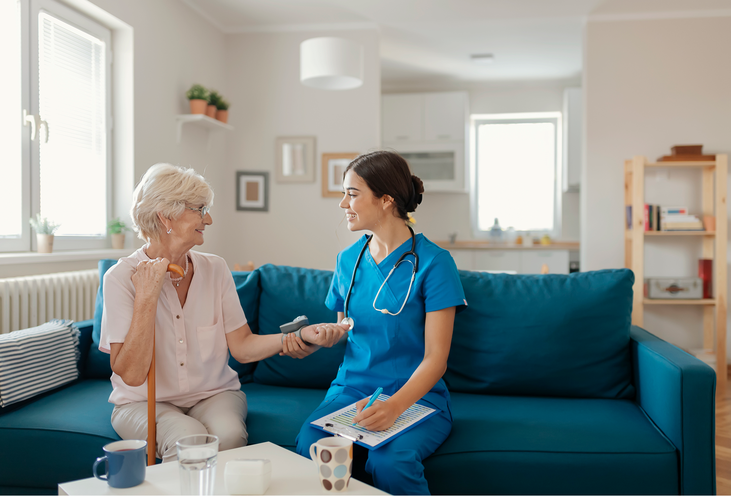 Nurse assisting elderly woman at home