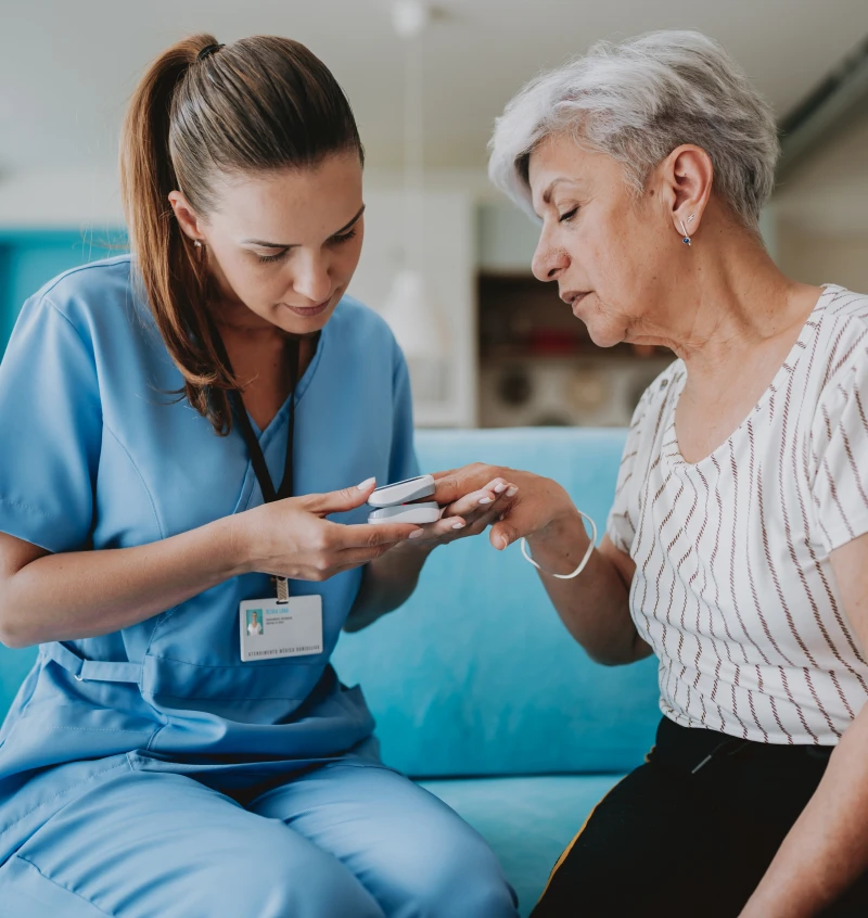 Nurse assisting elderly woman with medication