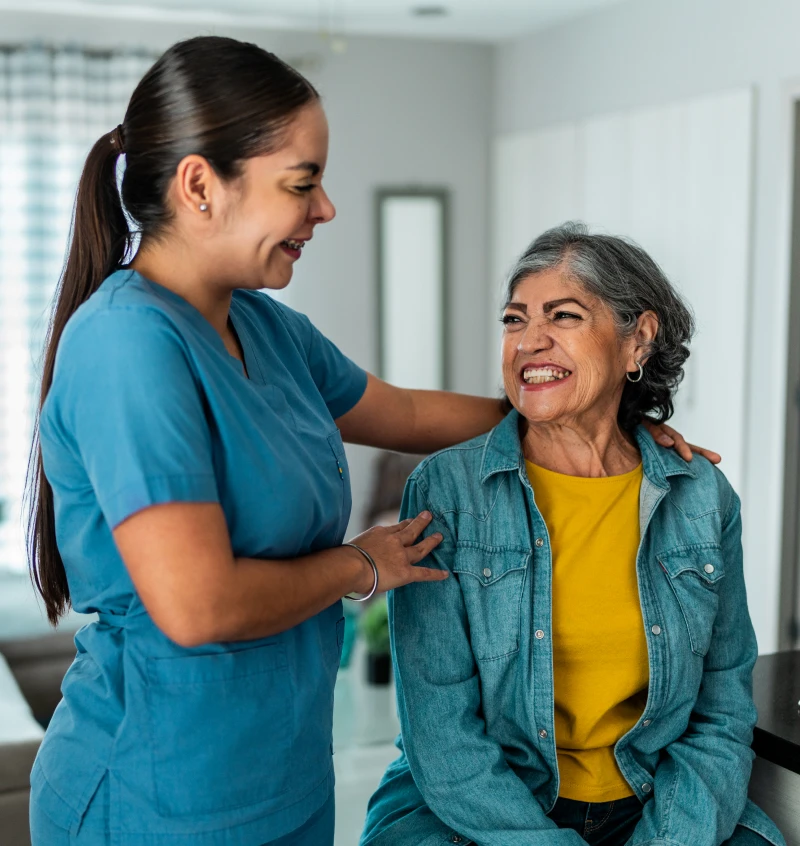 Caregiver with senior woman smiling together